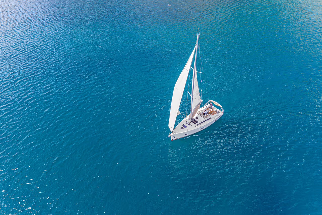 Ourson Blanc, voilier Dufour 430 sous voiles sur une mer bleue, vu du dessus